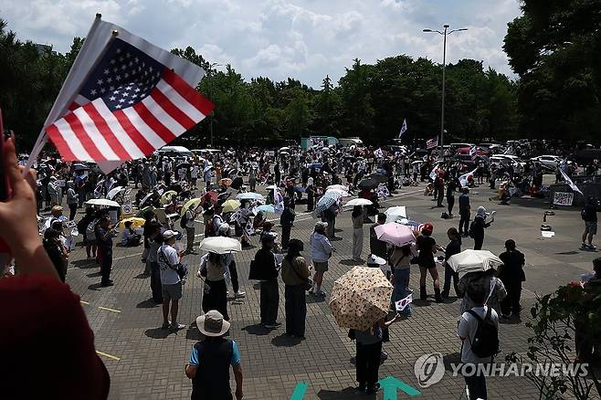 6·3 지방선거 개표소 봉쇄 시위 계속 (서울=연합뉴스) 윤동진 기자 = 6·3 지방선거 투표용지 부족 사태를 규탄하며 재선거를 요구하는 '잠실 개표소 봉쇄 시위'가 계속되고 있는 8일 서울 송파구 올림픽공원 핸드볼경기장 출입구 앞에서 참가자들이 구호를 외치고 있다. 2026.6.8 mon@yna.co.kr
