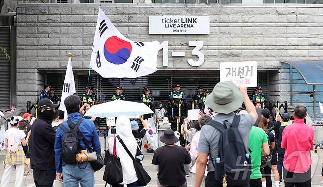 제9회 전국동시지방선거 투표용지 부족 사태를 규탄하며 재선거를 요구하는 집회가 계속되고 있는 8일 서울 송파구 올림픽공원 핸드볼경기장 개표소 앞에 모여 재선거를 요구하는 구호를 외치고 있다. 2026.6.8 ⓒ 뉴스1 김진환 기자