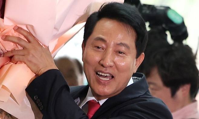 오세훈 서울시장이 4일 서울시청으로 들어서며 직원들에게 받은 꽃다발을 들고 있다. 연합뉴스