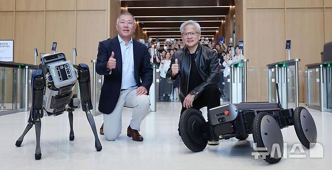 [서울=뉴시스] 김진아 기자 = 젠슨 황 엔비디아 최고경영자(CEO)와 정의선 현대차그룹 회장이 8일 서울 서초구 현대자동차그룹 양재사옥에서 4족 보행로봇 스팟(Spot)과 자율주행 모빌리티 로봇 모베드(MobED)에 사인한 뒤 기념촬영 하고 있다. (공동취재) 2026.06.08. photo@newsis.com