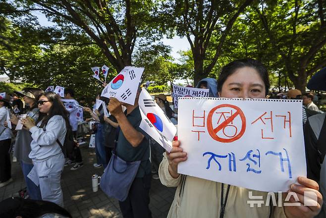 [서울=뉴시스] 정병혁 기자 = 제9회 전국동시지방선거 투표용지 부족 사태에 항의하며 개표소 봉쇄 시위를 이어가고 있는 9일 서울 송파구 올림픽공원 핸드볼경기장에 설치된 개표소 앞에서 구호를 외치고 있다. 2026.06.09. jhope@newsis.com