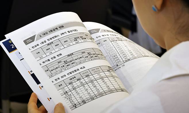 지난 7일 서울 강남종로학원 대강당에서 열린 6월 모의평가 긴급분석 및 2027 대입 예측 설명회에서 학부모들이 자료를 살펴보고 있다. 연합뉴스