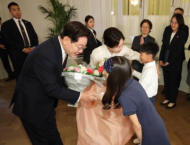 이재명 대통령과 김혜경 여사가 9일(현지 시각) 벨기에 브뤼셀 시내의 한 호텔에서 열린 동포 만찬간담회에서 화동으로부터 꽃다발을 받고 있다./연합뉴스