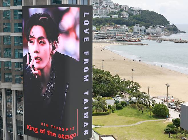 BTS의 공연을 앞두고 9일 부산 해운대해수욕장 앞 그랜드조선 호텔 외벽에 설치된 초대형 미디어 전광판에 방탄소년단(BTS) 뷔 사진이 송출되고 있다. [연합뉴스]