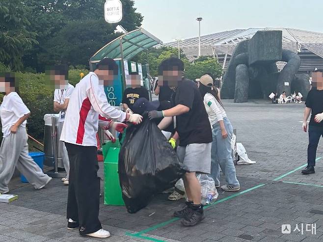 박모(25) 씨 등 20대 자원봉사자들이 8일 '재선거 요구' 시위가 열린 서울 송파구 올림픽공원 핸드볼경기장에서 쓰레기 분리수거를 하고 있다. /사진=최혜승 기자