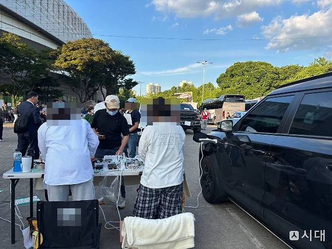 최은영씨 자매가 8일 '재선거 요구' 시위가 열린 서울 송파구 올림픽공원 핸드볼경기장에서 자신의 전기차에 멀티탭을 연결해 집회 참석자들의 휴대전화 배터리 충전을 도와주고 있다. /사진=최혜승 기자