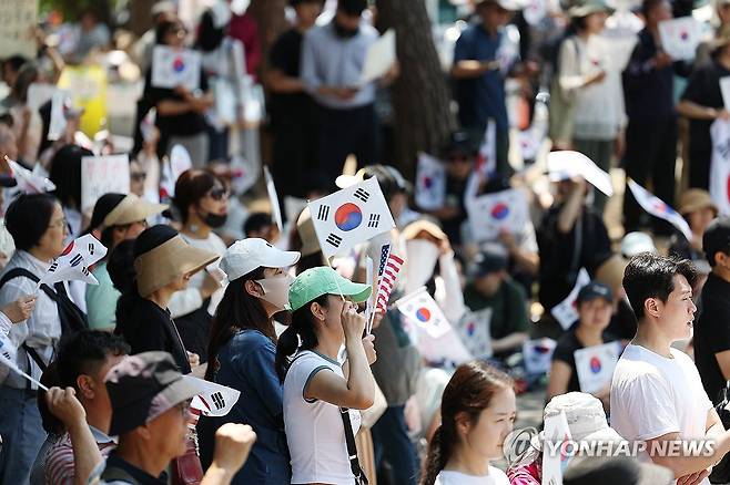 태극기 흔드는 개표소 봉쇄 시위 참가자 (서울=연합뉴스) 김성민 기자 = 6·3 지방선거 투표용지 부족 사태를 규탄하며 재선거를 요구하는 '잠실 개표소 봉쇄 시위'가 계속되고 있는 9일 서울 송파구 올림픽공원 핸드볼경기장에서 한 참가자가 태극기를 흔들고 있다. 2026.6.9 ksm7976@yna.co.kr