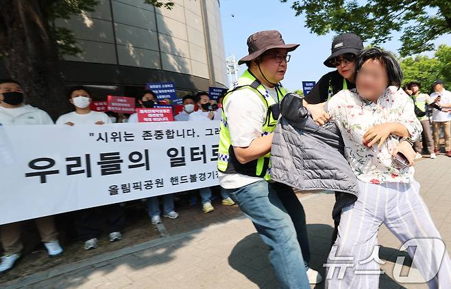 11일 서울 송파구 올림픽공원 핸드볼경기장 앞에서 열린 핸드볼경기장 입주 체육단체 직원들의 업무 정상화 호소문 발표 기자회견 도중 한 여성이 기자회견을 가로막으며 항의하고 있다. 2026.6.11 ⓒ 뉴스1 오대일 기자