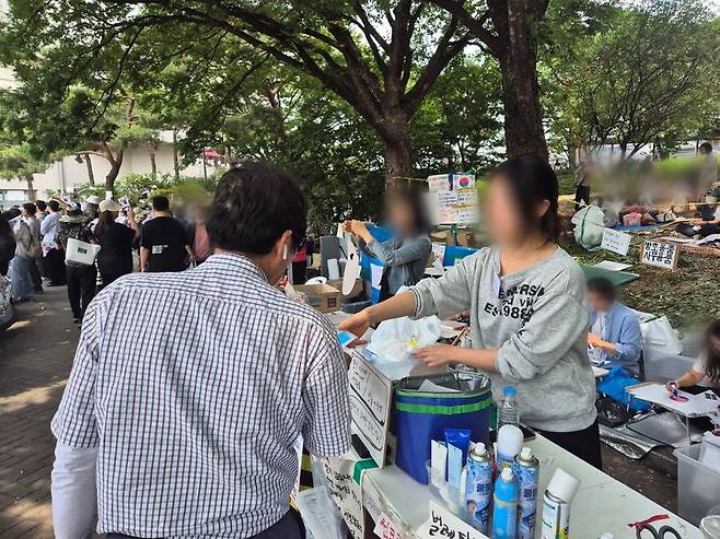 시민들에게 물과 음식, 벌레퇴치제 등을 제공하는 자원봉사자 이채빈씨. 사진=김예지 기자