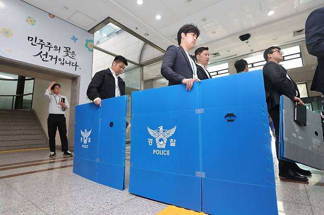 경찰 관계자들이 11일 경기도 과천시 중앙선거관리위원회에서 6ㆍ3 지방선거 투표지 부족사태 관련 압수수색을 위해 청사로 진입하고 있다. [연합뉴스]