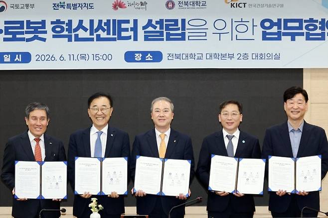 김윤덕(왼쪽 두 번째)국토교통부장관이 11일 오후 전북대학교에서 전북도, 전주시, 전북대, 한국선설기술연구원과 인공지능(AI) 건설·로봇 혁신센터 건립을 위한 업무협약을 체결한 뒤 협약서를 들어보이고 있다. 전북도 제공