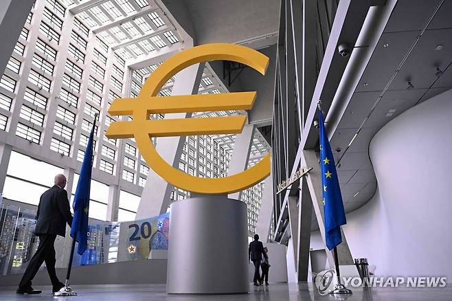 ECB, 3년만에 금리 인상 11일(현지시간) 독일 프랑크푸르트 유럽중앙은행(ECB) 본사의 대형 유로화 표식 옆으로 방문자가 지나가고 있다. 
[AFP=연합뉴스. 재판매 및 DB 금지]