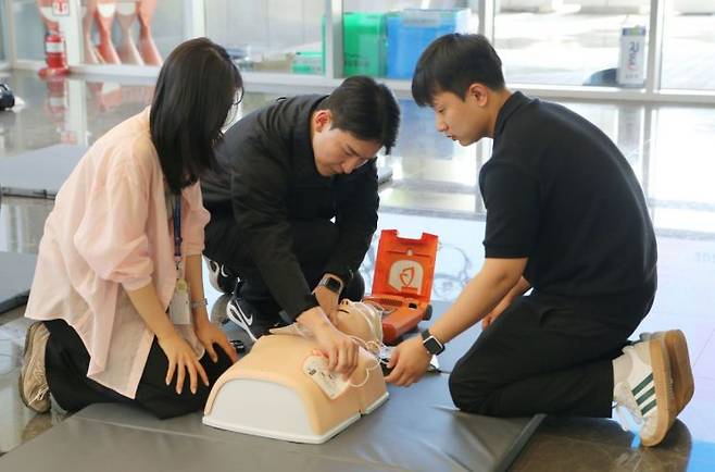 에어부산 임직원들이 지난 11일 부산 강서구 소재 에어부산 사옥에서 실시된 산업재해 비상 대응 훈련에 참여해 자동심장충격기(AED) 사용법 교육을 받고 있다. 에어부산 제공