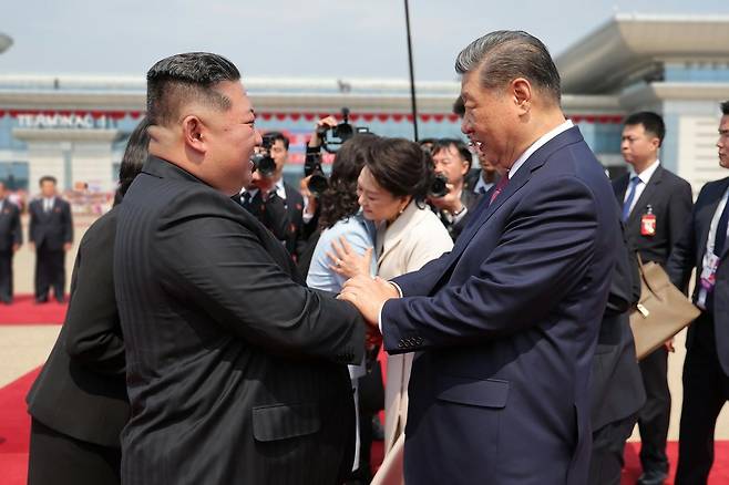김정은(왼쪽) 북한 국무위원장이 9일 평양 순안공항에서 이틀간의 방북 일정을 마치고 돌아가는 시진핑 중국 국가주석과 인사하고 있다. 평양=노동신문 뉴스1