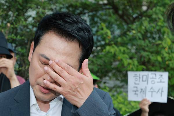 국민의힘 장동혁 대표가 16일 '투표용지 부족 사태' 시위대가 점거한 서울 송파구 올림픽공원 핸드볼경기장 인근에서 같은 당 의원들과 대한체육회 산하 체육단체 직원의 사무실 진입 관련 논의를 하며 눈가를 만지고 있다. /연합뉴스