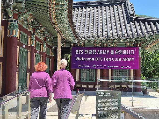 BTS 공연을 맞아 사찰을 방문한 팬들이 BTS의 상징색인 보라색 옷을 입은 두 명의 아미(ARMY)가 지난 12일 오전 산책을 마치고 숙소로 들어서고 있다. News1