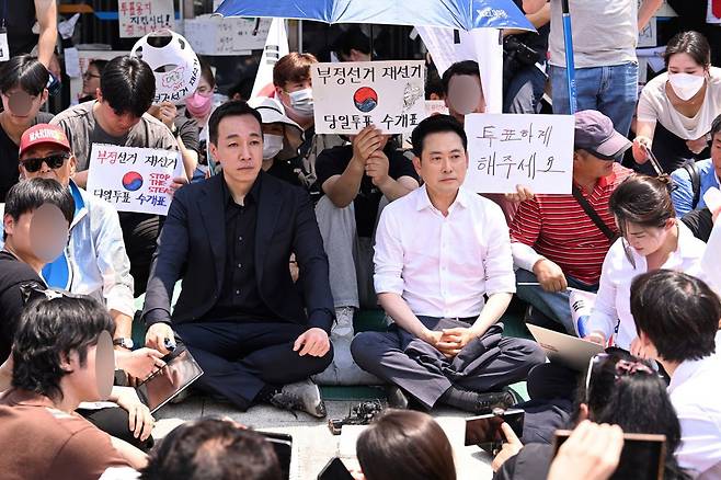 장동혁 국민의힘 대표와 김민수 국민의힘 최고위원이 16일 서울 송파구 올림픽공원 핸드볼경기장 2-1 출입구 앞에 앉아 있다. 변영욱 기자 cut@donga.com