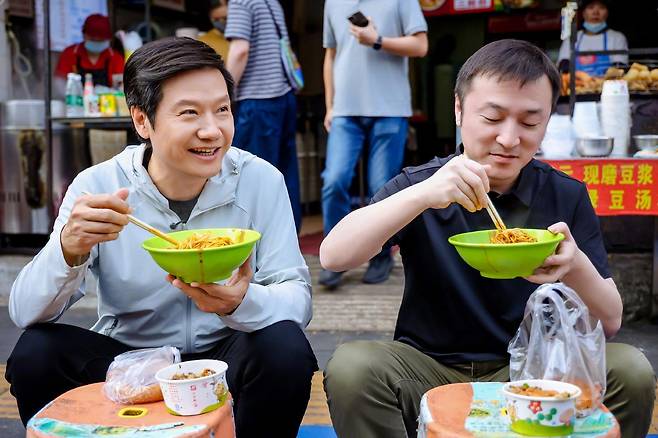 레이쥔 샤오미 최고경영자(왼쪽)가 중국 우한에서 국수 등 길거리 음식을 먹는 모습을 소셜네트워크서비스(SNS)에 공개했다. 웨이보 캡처