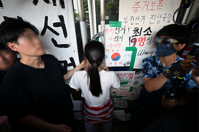 6·3 지방선거 투표용지 부족 사태로 시작된 올림픽공원 핸드볼경기장 봉쇄 시위가 이어지고 있다. 사진은 16일 시위에 참여한 시민이 대한체육회 관계자들의 핸드볼경기장 진입을 막고 있는 모습. [연합뉴스]