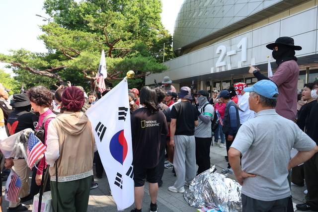 일부 시위 참가자들이 16일 오전 서울 송파구 올림픽공원 핸드볼경기장 앞에서 경찰의 경기장 진입 시도에 항의하고 있다.  뉴시스