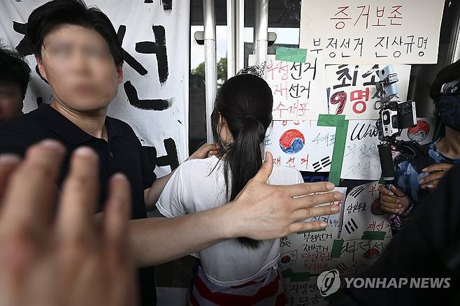 잠실 핸드볼경기장 진입 저지하는 시위 참가자 (서울=연합뉴스) 서대연 기자 = 6·3 지방선거 투표용지 부족 사태로 시작한 서울 송파구 올림픽공원 핸드볼경기장 일대 '개표소 봉쇄 시위'가 이어지는 가운데 16일 한 시위 참가자가 대한체육회 등 입주 단체 관계자들의 진입을 막아서고 있다. 2026.6.16 [공동취재] dwise@yna.co.kr