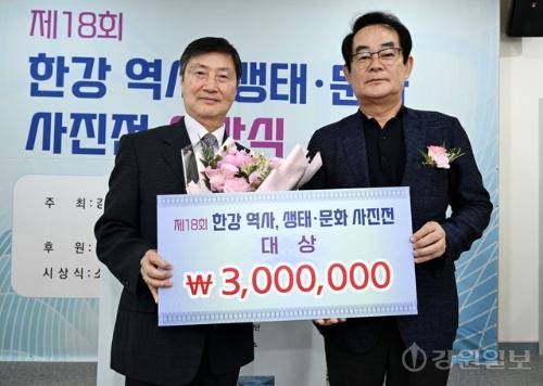 17일 춘천시 소양강댐 물 문화관에서 열린 제18회 한강 역사, 생태·문화 사진공모전 시상식에서 대상을 수상한 유영철씨(왼쪽)가 박진오 강원일보 사장으로부터 축하 꽃다발을 전달받고 기념촬영을 하고 있다. 임도혁기자