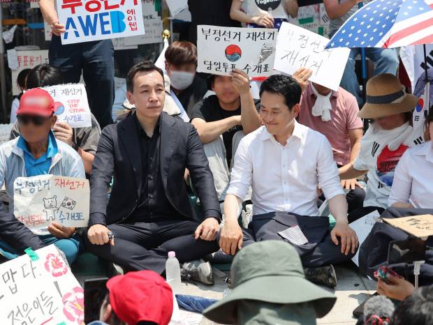 6·3 지방선거 투표용지 부족 사태로 촉발된 잠실 개표소 봉쇄 시위가 이어진 16일 국민의힘 장동혁 대표, 김민수 최고위원이 서울 송파구 올림픽공원 핸드볼경기장 개표소 앞에 자리를 잡고 앉아 있다. 연합뉴스