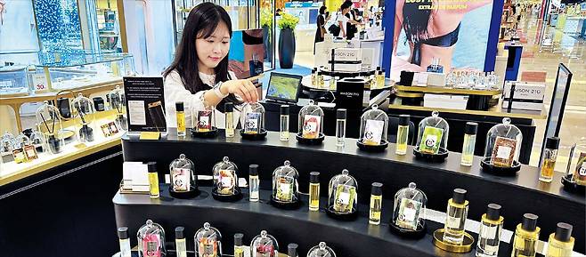 서울 송파구 롯데백화점 잠실점 본관 1층에 마련된 ‘니치향수 특화존’에서 직원이 향수 제품을 살펴보고 있다. 최근 직접 향을 맡아보고 구매하는 소비자가 늘면서 종전 향수 매장보다 면적과 입점 브랜드 수를 2배 가까이로 늘렸다. /롯데백화점
