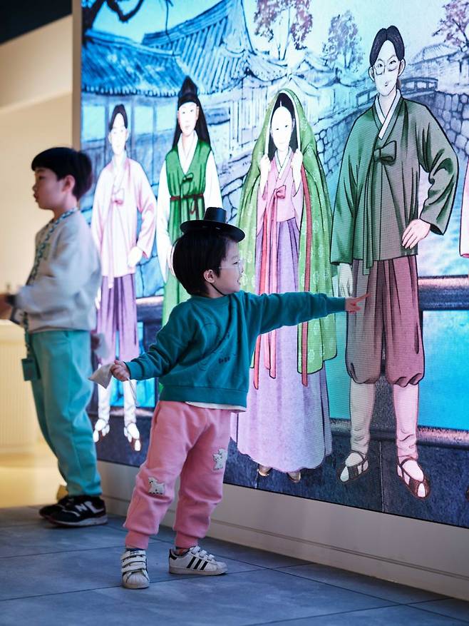 대한민국역사박물관에서 한 어린이가 그림 전시를 보고 있다.