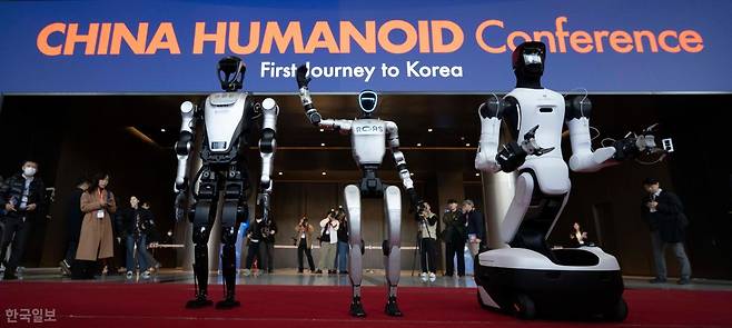3월 4일 서울 강남구 코엑스에서 열린 2026 스마트공장·자동화산업전에서 관람객이 중국 로봇 기업의 휴머노이드 로봇이 관람객들을 향해 인사하고 있다. 왼쪽부터 애지봇의 G2, 유니트리의 G1, 레쥬의 쿠아보 4 프로. 강예진 기자