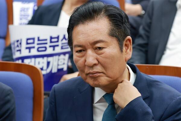 정청래 더불어민주당 대표가 18일 국회에서 본회의를 앞두고 열린 의원총회에 참석해 옷매무새를 정리하고 있다. 연합뉴스