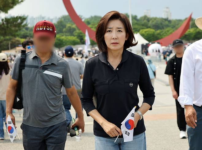 나경원 국민의힘 의원이 지난 14일 6·3 지방선거 투표용지 부족 사태를 규탄하는 ‘개표소 봉쇄 시위’가 이어지고 있는 서울 송파구 올림픽공원 핸드볼경기장을 찾아 태극기를 들고 이동하고 있다. 연합뉴스