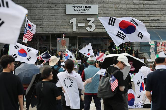 태극기와 성조기를 든 시민들이 18일 서울 송파구 올림픽공원 핸드볼경기장 앞에서 개표소 봉쇄 시위를 하고 있다. 연합뉴스