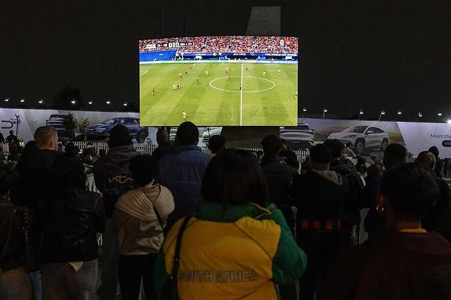 18일 남아프리카공화국 요하네스버그 멜로즈 아치에서 남아공 축구 팬들이 2026 FIFA 월드컵 조별리그 2차전 체코-남아공 경기 생중계를 지켜보고 있다. 경기는 1-1 무승부로 끝났다. 요하네스버그/AFP연합뉴스