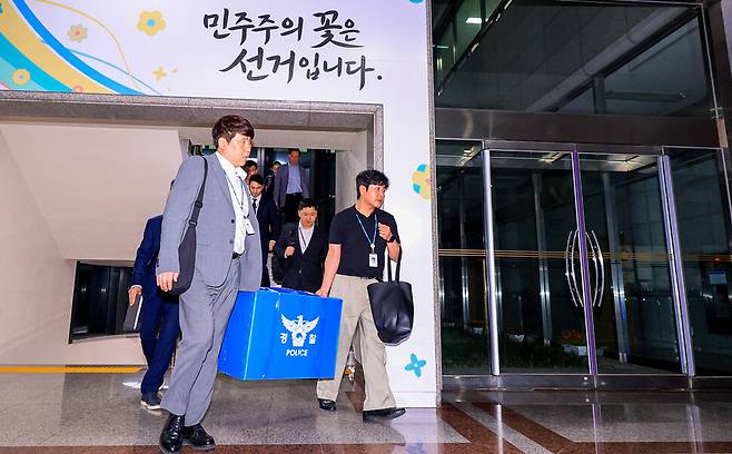 6·3 전국동시지방선거 투표용지 부족 사태를 수사 중인 검경 합동수사본부 관계자들이 2026년 6월11일 경기도 과천 중앙선거관리위원회에서 압수수색한 물품을 들고 건물을 나서고 있다. 연합뉴스