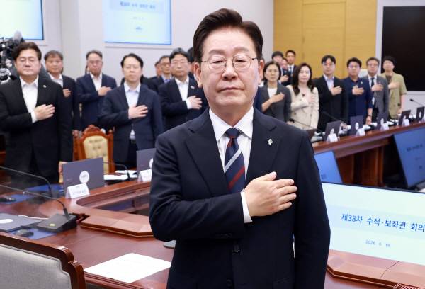 이재명 대통령이 19일 청와대에서 열린 수석보좌관회의에서 국기에 경례하고 있다. 연합뉴스