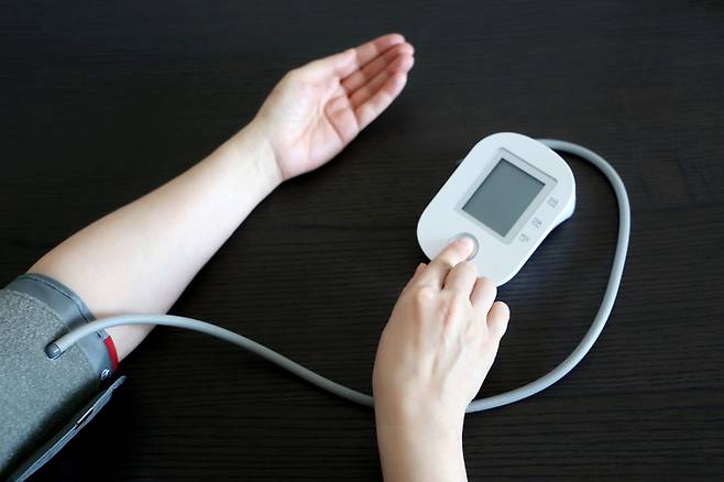 중년 여성이 혈압을 재고 있다. 왼팔 혈압과 오른팔 혈압의 차이가 10mmHg 이하(수축기혈압 기준)여야 정상이다. 양팔 혈압 차이가 90mmHg나 되는 60대 혈관염(타카야스동맥염) 환자의 사례가 학계에 보고됐다. 양팔 혈압 중 높은 쪽을 기준 측정치로 삼아야 한다. 사진=게티이미지뱅크
