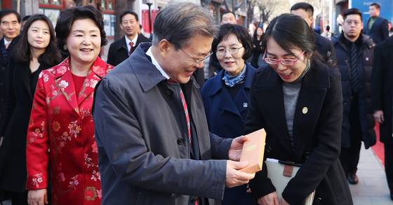 유리창 거리 탐방을 도운 중국 대사관 직원에게 '이니시계'를 선물하는 문재인 대통령. 연합뉴스