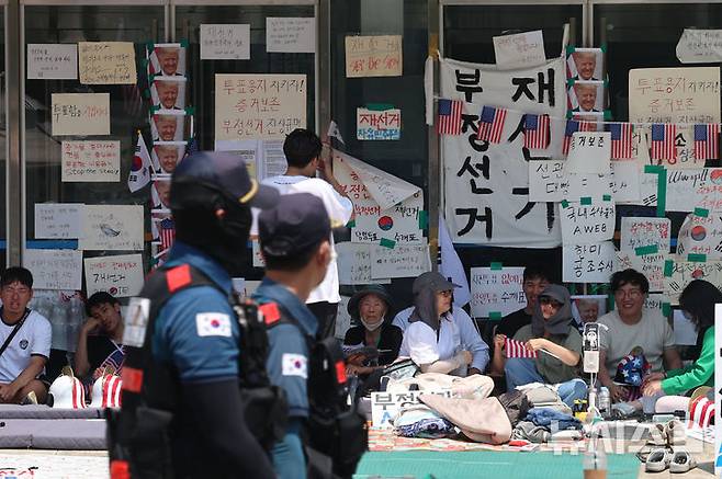 [서울=뉴시스] 권창회 기자 = 제9회 전국동시지방선거 투표용지 부족 사태에 항의하며 개표소 봉쇄 시위를 이어가고 있는 17일 서울 송파구 올림픽공원 핸드볼경기장에 설치된 개표소 문 앞을 시민들이 지키고 있다. 2026.06.17. kch0523@newsis.com