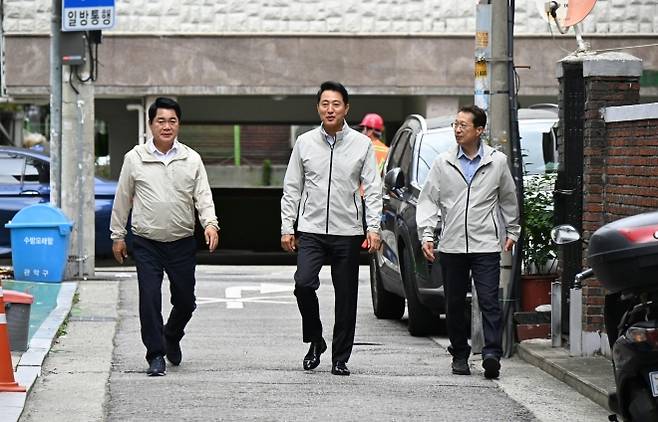 오세훈(가운데) 서울시장과 박준희(왼쪽) 관악구청장이 22일 관악구 일대 침수우려지역의 풍수해 안전대책 시설을 점검하기 위해 이동하고 있다. 서울시 제공
