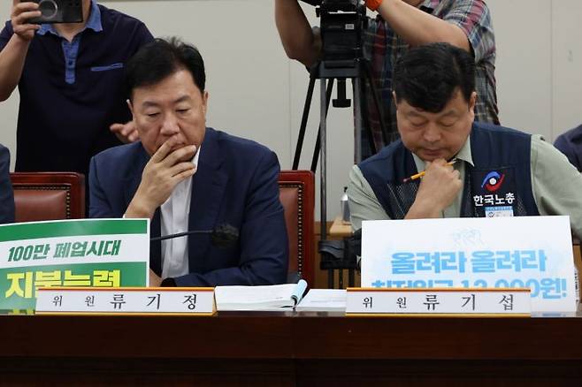23일 정부세종청사에서 열린 제8차 전원회의에서 사용자위원인 류기정 한국경영자총협회(경총) 전무(왼쪽)와 근로자위원인 류기섭 한국노총 사무총장이 굳은 표정으로 발언을 듣고 있다. 연합뉴스
