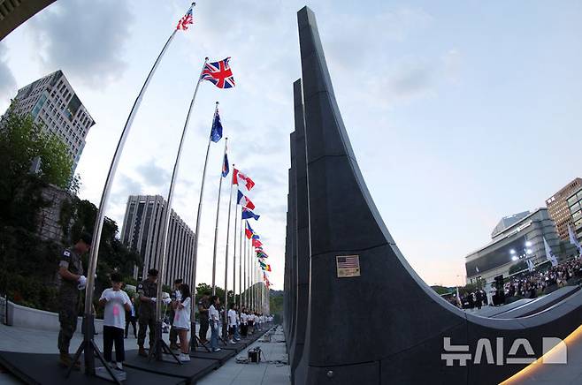 [서울=뉴시스] 조성우 기자 = 23일 서울 종로구 광화문광장 감사의 정원에서 열린 6·25전쟁 제76주년 기념식에서 어린이기자단과 수방사 군인들이 참전국 국기 게양식을 하고 있다.   2026.06.23. xconfind@newsis.com