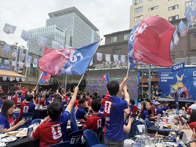 서울 을지로 달맞이광장바베큐 '카스 뷰잉펍'에서 25일 열린 한국 축구 국가대표팀의 경기를 참가자들이 응원하고 있다. ⓒ 뉴스1 황두현 기자