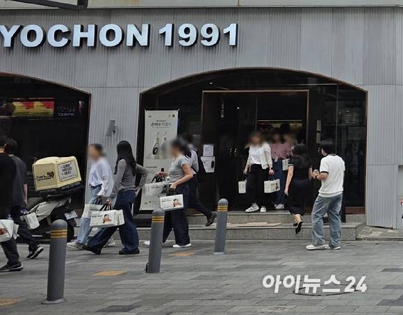 25일 오전 9시40분께 서울 종각역 인근 교촌치킨 종로1호점에서 시민들이 포장 주문한 치킨을 들고 나오는 모습. [사진=구서윤 기자]