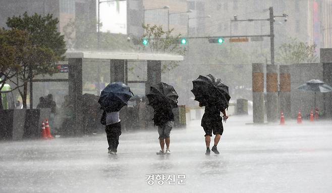 지난 14일 서울 종로구 광화문광장에 거센 비가 내리자 시민들이 우산을 쓰고 걸어가고 있다. 권도현 기자