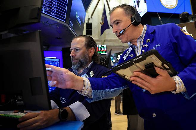 24일(현지 시간) 미국 맨해튼 뉴욕증권거래소(NYSE)의 거래중개인들이 증시 화면을 살펴보고 있다. 로이터연합뉴스