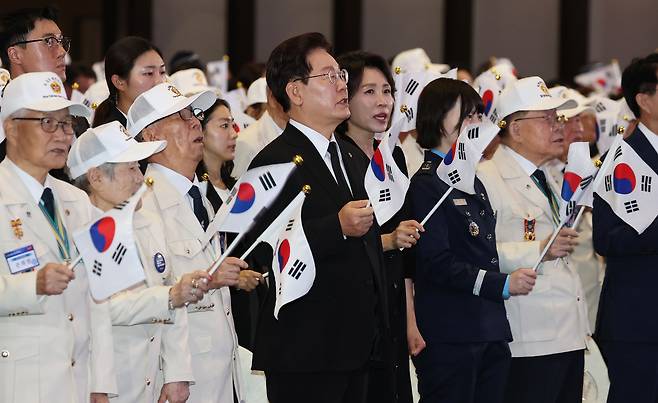 이재명 대통령과 김혜경 여사가 25일 수원컨벤션센터에서 열린 6·25 전쟁 제76주년 기념식에서 참석자들과 기념 노래를 부르고 있다. 연합뉴스