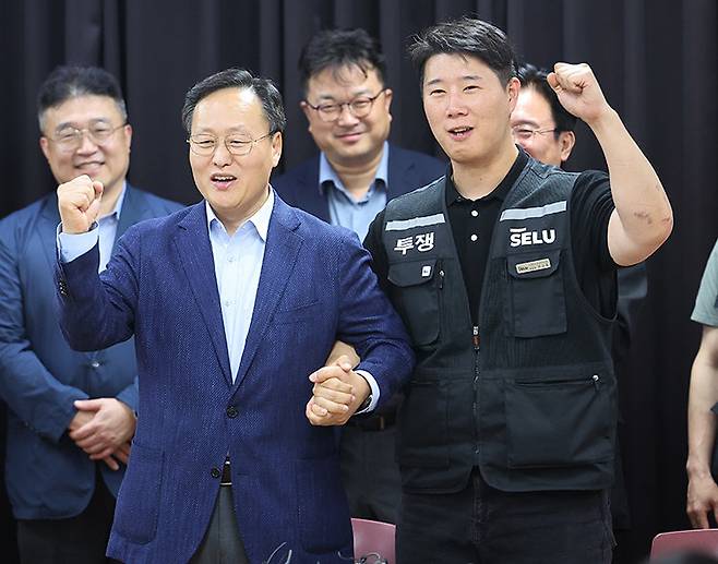 5월 20일 경기 수원시 경기지방고용노동청에서 삼성전자 노사가 2026년 임금협약 잠정 합의안에 서명한 뒤 여명구 삼성전자 DS부문 피플팀장(부사장·앞줄 왼쪽)과 최승호 삼성 초기업노조 삼성전자지부 위원장이 한 손을 맞잡고 파이팅을 외치고 있다. 삼성전자 노사는 지난해 12월 16일 본교섭을 시작한 지 156일 만에 총파업 직전 임금협약 잠정 합의안을 이끌어냈다. 동아DB