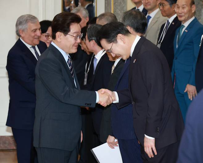 이재명 대통령이 지난 12일(현지시간) 이탈리아 로마의 한 호텔에서 열린 비즈니스 라운드테이블에 입장하며 이재용 삼성전자 회장과 악수하고 있다. /연합뉴스