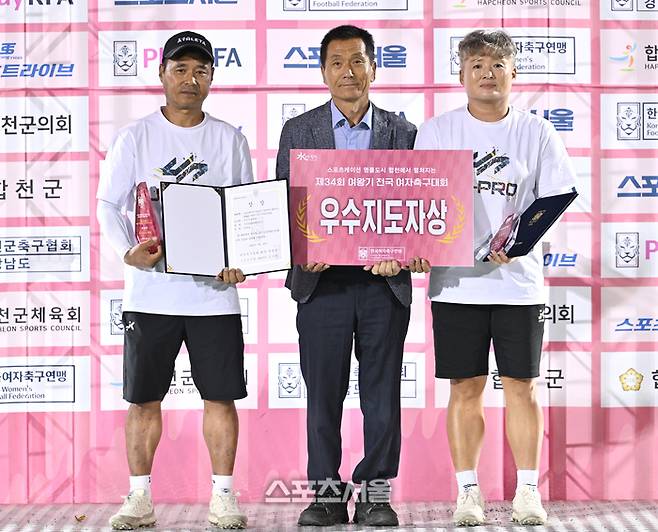 부산 SAHAWFCU12 정수진 감독(오른쪽)과 박영호 코치가 25일 합천 군민체육공원에서 열린 ‘2026 스포츠케이션 명품도시 합천에서 펼쳐지는 제34회 여왕기 전국여자축구대회’ 초등부 시상식에서 우수지도자상을 수상한 후 합천군축구협회 곽용완 부회장과 포즈를 취하고 있다.   2026. 6. 25. 합천 | 최승섭기자 thunder@sportsseoul.com